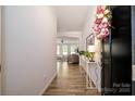Bright foyer with wood-look flooring, neutral walls, and a glimpse into the open living space at 7036 Heron Rookery Way, Charlotte, NC 28214