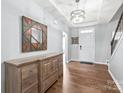 Bright foyer with hardwood floors, tray ceiling, decorative chandelier and wooden console table at 7662 Tanglewood Way, Denver, NC 28037