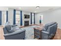 Bright living room with hardwood floors, blue sofas, fireplace, and modern decor at 7662 Tanglewood Way, Denver, NC 28037