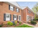 Traditional brick townhouse with black shutters, and a neatly maintained lawn at 8308 Knights Bridge Rd, Charlotte, NC 28210