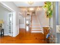 Inviting foyer with hardwood floors, a staircase, and views into other living spaces at 8621 Sequoia Grove Ln, Charlotte, NC 28214