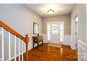 Bright foyer featuring hardwood floors, a stylish table, and a decorative front door at 8621 Sequoia Grove Ln, Charlotte, NC 28214