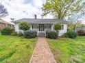 Charming single-story home featuring a brick walkway and inviting front porch at 11 Tallassee St, Badin, NC 28009