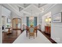 Dining room with coffered ceilings, statement chandelier, dark wood floors, and natural light at 138 Great Point Dr, Mooresville, NC 28117