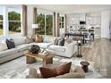 Bright, open-concept living room and kitchen with natural light, modern furnishings, and wood flooring at 1440 Mccollum St, Monroe, NC 28112