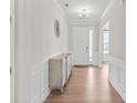 Bright entryway with gleaming wood floors, modern lighting, elegant wainscoting, and decorative wall art at 15126 Shallow Ridge Rd, Charlotte, NC 28278