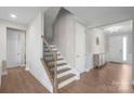 Inviting entryway with wood floors, staircase, modern lighting, and view to the front door at 15126 Shallow Ridge Rd, Charlotte, NC 28278