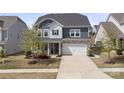 Charming two-story home featuring stone accents, a two-car garage, manicured lawn, and covered porch entry at 15126 Shallow Ridge Rd, Charlotte, NC 28278