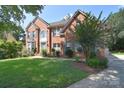 Attractive brick home with a lush green lawn and mature landscaping at 15964 Cumnor Ln, Charlotte, NC 28277