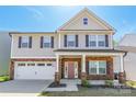 Charming two-story home with a two-car garage, manicured lawn, and covered front porch at 162 Aspire Cir, Wingate, NC 28174