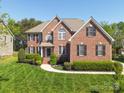 Beautiful brick home with meticulously maintained lawn and landscaping, showcasing timeless curb appeal at 202 Weeping Spring Dr, Mooresville, NC 28115