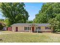 Charming ranch-style home with inviting front porch and mature trees, perfect for serene outdoor living at 2115 Fowler Secrest Rd, Monroe, NC 28110