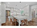 Bright kitchen boasts white cabinets, marble island with bar seating, and stainless steel appliances at 2915 Cross Country Rd, Charlotte, NC 28270