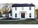 Beautiful two-story home with a white brick exterior, black roof, and manicured landscaping at 314 Bass Ln, Charlotte, NC 28270