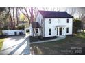 Beautiful home with a white brick exterior, black roof, and a long drive at 314 Bass Ln, Charlotte, NC 28270