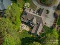 Aerial view of a luxurious home with an outdoor firepit and pristine landscaping at 3160 Ashwood Park Dr, Belmont, NC 28012