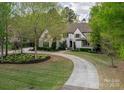 Landscaped lawn leading to a house featuring manicured greenery and a circular driveway at 3160 Ashwood Park Dr, Belmont, NC 28012