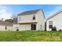 View of the back of the house with a sliding glass door overlooking a large grassy backyard at 3320 Alderknoll Ct, Charlotte, NC 28216