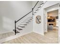 Beautiful staircase with black and white banister leading to the upper level with light hardwood floors at 3383 Norwich Rd, Fort Mill, SC 29715