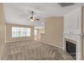 Bright living room with a cozy fireplace, neutral carpet, and large windows at 3411 Xandra Ct, Indian Land, SC 29707