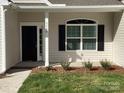 Inviting front entrance with black door, detailed trim, and manicured landscaping at 5126 Rocky River Crossing Rd, Harrisburg, NC 28075