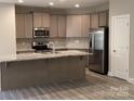 Well-lit kitchen features stainless steel appliances and granite countertops for modern cooking at 5126 Rocky River Crossing Rd, Harrisburg, NC 28075