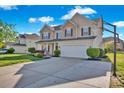 Two-story home with a well-maintained front lawn, driveway, and attached two-car garage under a clear sky at 6115 The Meadows Ln, Harrisburg, NC 28075