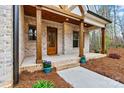 Inviting front porch with brickwork, wooden support beams, and decorative flower pots at 6654 Maple Spring Ct, Denver, NC 28037