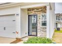 Close-up of the front door with decorative stone detail and a small garden area at 10002 Brittondale Ln, Charlotte, NC 28215