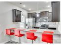 Modern kitchen featuring dark cabinets, stainless steel appliances, and a granite countertop bar at 10002 Brittondale Ln, Charlotte, NC 28215