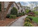 Lovely brick home featuring a curved walkway framed by verdant greenery and meticulously maintained landscaping at 104 Chalfont Ct, Salisbury, NC 28147