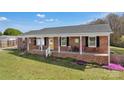 Charming brick ranch home with a cozy front porch, yellow door, and landscaped front yard at 109 Connor Ct, Kings Mountain, NC 28086