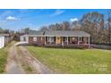 Charming brick ranch home with a cozy front porch, yellow door, and spacious front yard at 109 Connor Ct, Kings Mountain, NC 28086