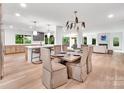 Open-concept dining area with a large table, modern lighting, and views of the kitchen and living space at 117 Wrenwood Ln, Charlotte, NC 28211