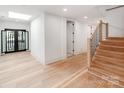Elegant foyer with wood flooring, light fixtures, double door entry, and staircase at 117 Wrenwood Ln, Charlotte, NC 28211