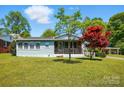 Quaint single-story home with a cozy front porch and lush green lawn, offering a welcoming curb appeal at 140 Oak Ave, Mount Holly, NC 28120