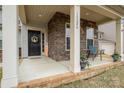 Inviting front porch with brick accents, seating, and a decorative front door at 15324 Colonial Park Dr, Huntersville, NC 28078
