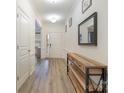 Bright hallway with hardwood floors, modern decor, and a view of the front door at 15324 Colonial Park Dr, Huntersville, NC 28078
