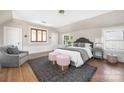 Bright bedroom with hardwood floors, a gray accent chair, and a large, comfortable bed at 1842 Asheville Pl, Charlotte, NC 28203