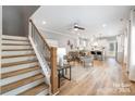 Open-concept living space with wood floors, stairs, and kitchen with white cabinetry and modern appliances at 2003 Ashley Rd # A, Charlotte, NC 28208