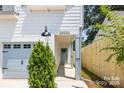Close up of a charming townhome with a single-car garage and walkway to the front door at 2003 Ashley Rd # B, Charlotte, NC 28208