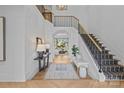 Bright foyer with hardwood floors, statement staircase, and view into living area at 2637 Normandy Rd, Charlotte, NC 28209