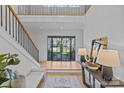 Bright, airy foyer features hardwood flooring, a staircase, and designer furnishings at 2637 Normandy Rd, Charlotte, NC 28209