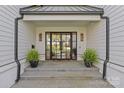 Home's stylish double-door entry featuring glass panels, stone steps, and decorative plants at 2637 Normandy Rd, Charlotte, NC 28209