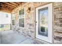 Covered front porch boasts stone accents, a decorative glass front door, and ambient lighting, enhancing curb appeal at 3010 Berry Creek Rd, Charlotte, NC 28214