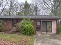 Single story brick home with covered front entrance and attached garage sits on a large wooded lot at 307 Brook St, Salisbury, NC 28146