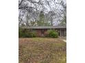 Single story brick home with covered front entrance and attached garage sits on a large wooded lot at 307 Brook St, Salisbury, NC 28146