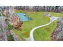 Aerial view of a beautiful property with a pond, expansive lawn and winding driveway at 317 Boyd Rd, Clover, SC 29710