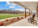 Inviting covered porch with rocking chairs overlooking a spacious lawn and pond at 317 Boyd Rd, Clover, SC 29710
