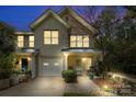 Inviting townhome featuring stone accents, cozy porch, and manicured landscaping at dusk at 3414 Chagall Ct, Charlotte, NC 28205